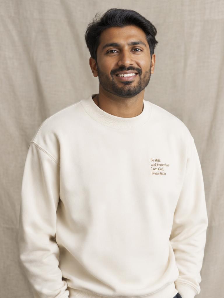 Man wearing a cream scripture crewneck sweater